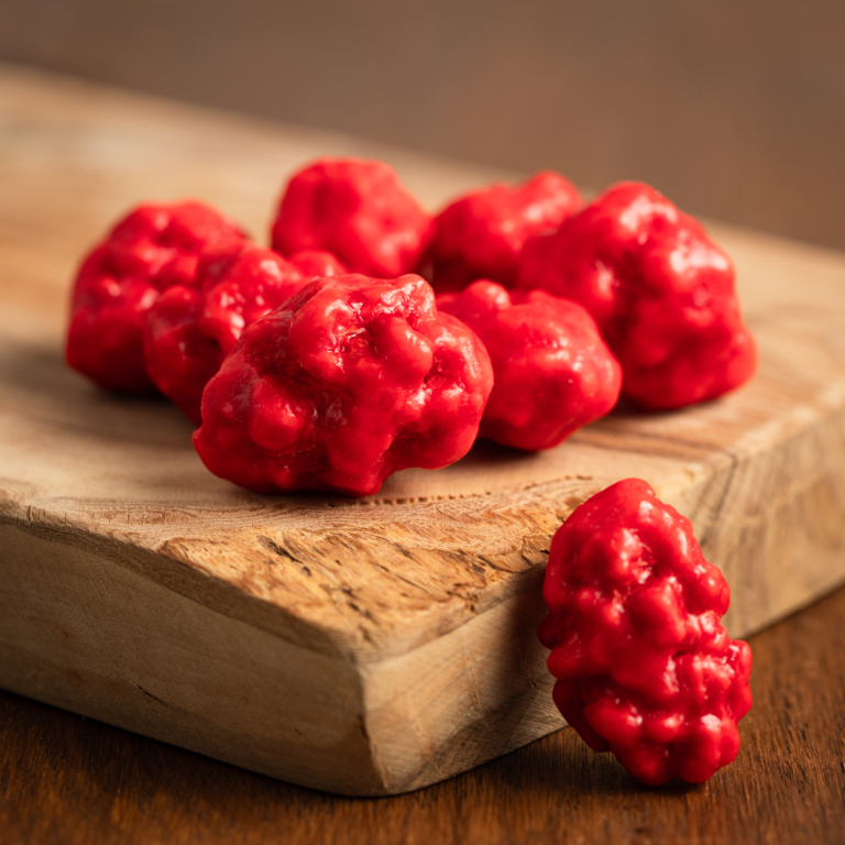 Les pralines amandes entières sont bosselées et de différentes tailles. La couleur de l'enrobage est rouge et d'aspect brillant à l'extérieur. On observe une couleur rose mate à l'intérieur des pralines. Le goût est sucré, légèrement aromatisé à la vanille et parfumé par l'amande délicatement grillée.