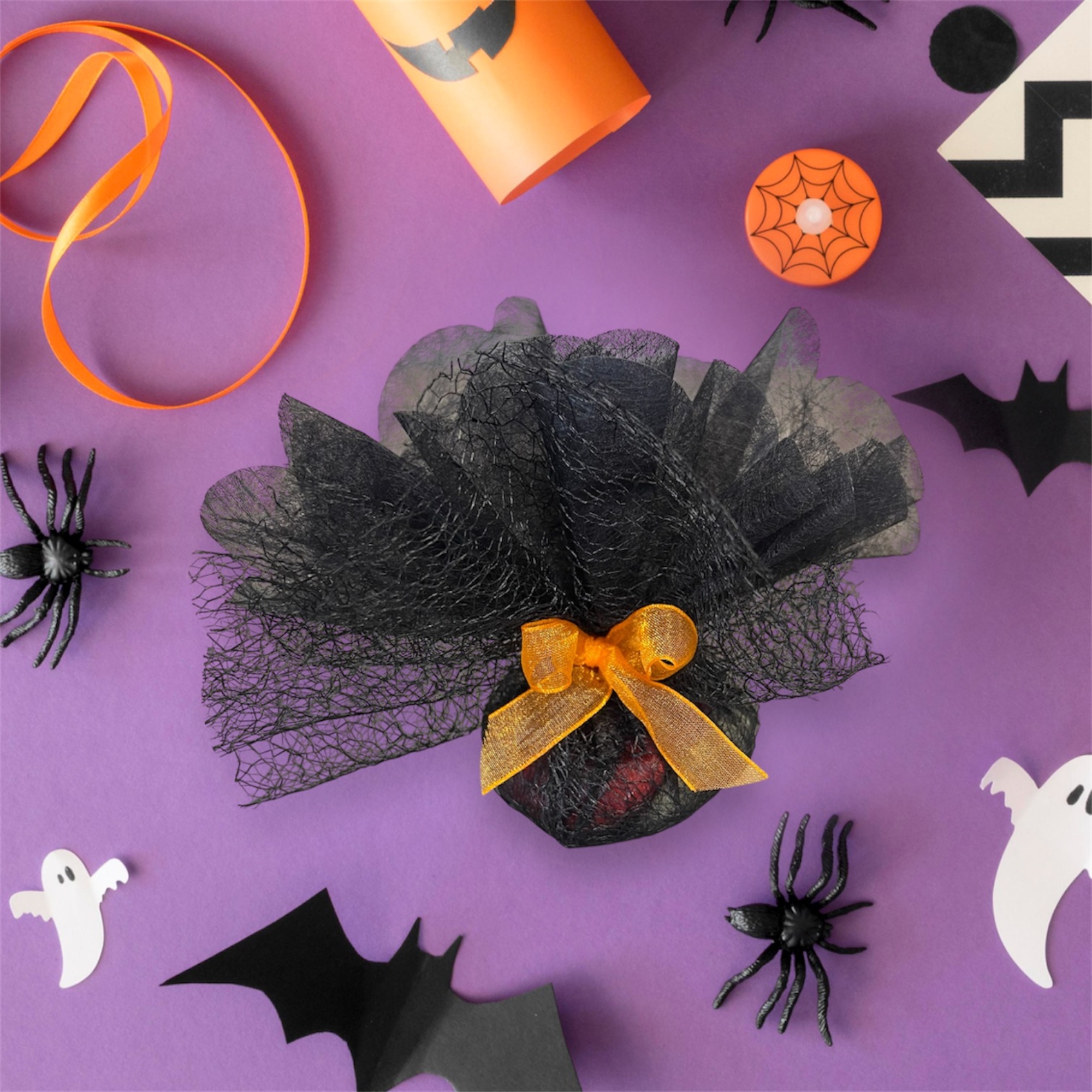 Ballotin chocolats d'Halloween noirs avec un ruban orange : Une association savoureuse de dragées chocolat, nougatine et de dragées au cœur coulant caramel généreusement enrobées de chocolat ! Traces possibles de : amande, noisette.